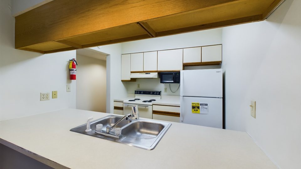 a kitchen with a sink and a stove top at The Chesterfield Apartments