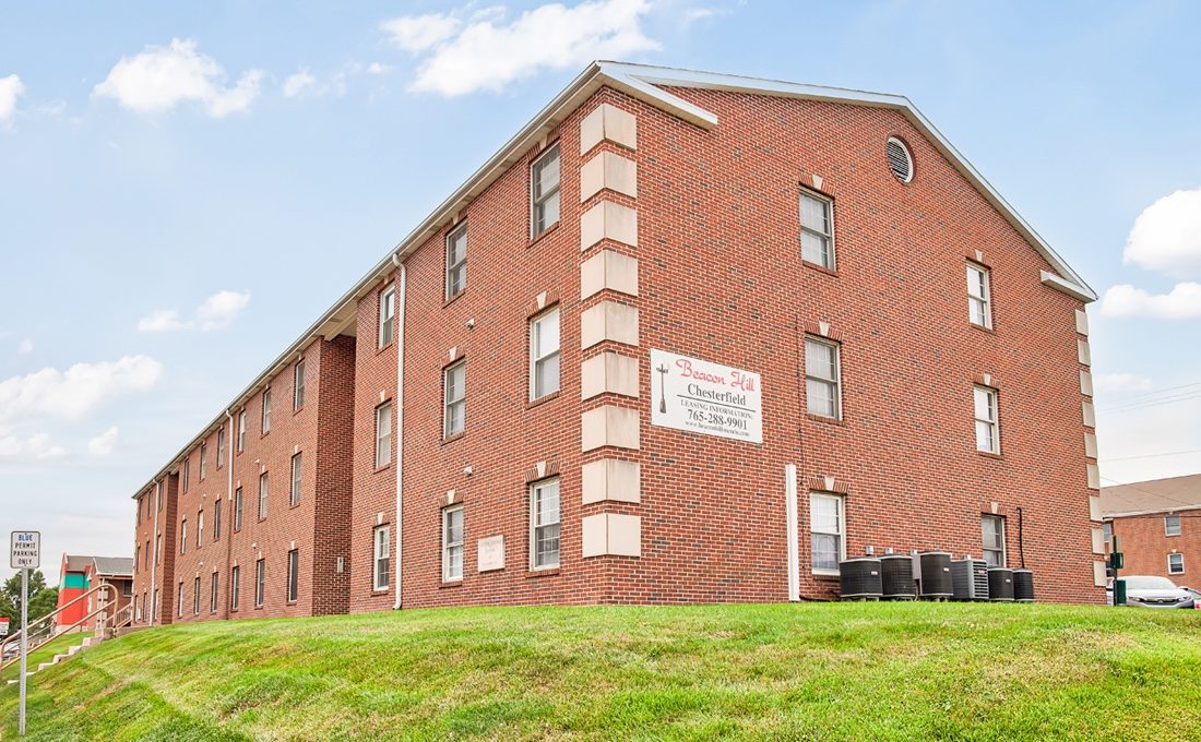 a brick apartment building on a grassy hill at The Chesterfield Apartments