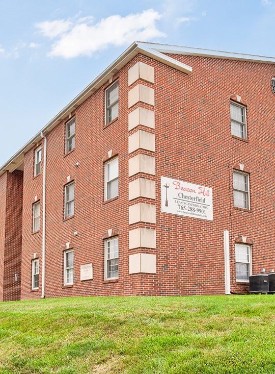 a brick apartment building on a grassy hill at The Chesterfield Apartments